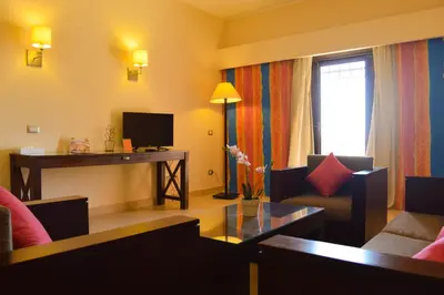 a living room with a couch and a table and a television at Viva Blue Resort and Diving Sharm El Naga (Adults Only) in Hurghada
