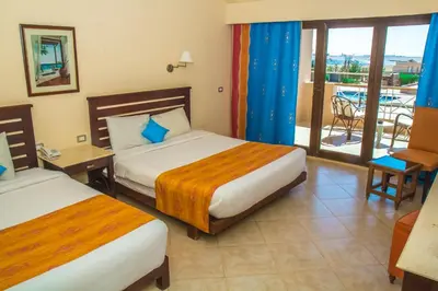 a hotel room with two beds and a balcony at Viva Blue Resort and Diving Sharm El Naga (Adults Only) in Hurghada