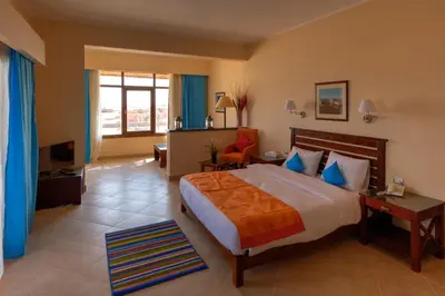 a hotel room with a bed and a television at Viva Blue Resort and Diving Sharm El Naga (Adults Only) in Hurghada
