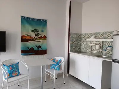a kitchen with a white table and two chairs at Pool view studio with terrace in Hurghada