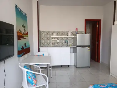 a kitchen with a table and a refrigerator at Pool view studio with terrace in Hurghada