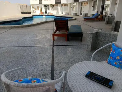 a bottle of wine sitting on a table next to a pool at Pool view studio with terrace in Hurghada