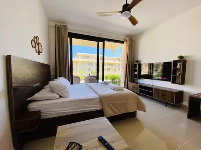 a bedroom with a large bed and a large window at A Bright Studio @GCribs - El Gouna W/ Shared pool! in El Gouna
