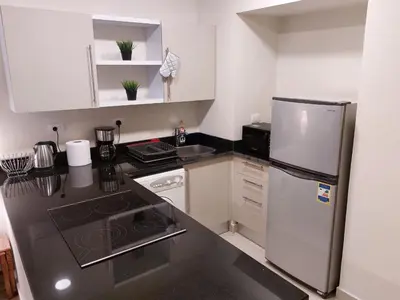a kitchen with a stainless steel refrigerator and white cabinets at Cozy, Calm, Studio in Veranda Sahl Hasheesh Resort in Hurghada
