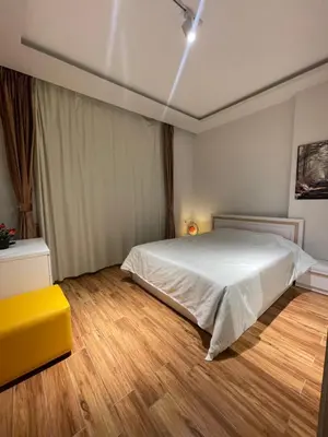 a bedroom with a white bed and a yellow stool at Modern HOME DownTown in Hurghada