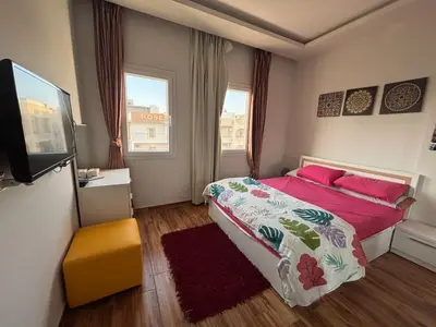 a bedroom with a bed and a flat screen tv at Modern HOME DownTown in Hurghada