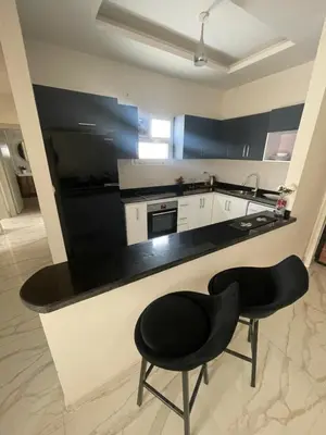 a kitchen with two black chairs and a counter at Modern HOME DownTown in Hurghada