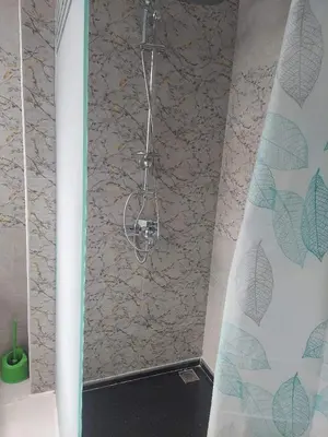 a shower in a bathroom with a stone wall at Makramia New Studio near to the beach in Hurghada