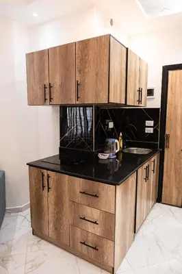 a kitchen with wooden cabinets and a black counter top at Juliana Beach Hurghada in Hurghada