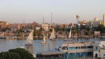 a group of sailboats on a river in a city at Ezzo Nubian guest house in Aswan