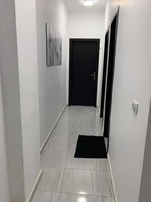 a hallway with a black door and a black rug at Marina View Apartment in Hurghada