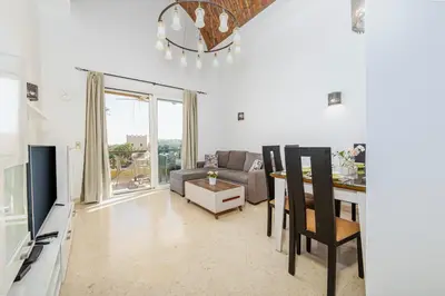 a living room with a couch and a table with a television at Wonderful apartment with prime location & pool in Hurghada