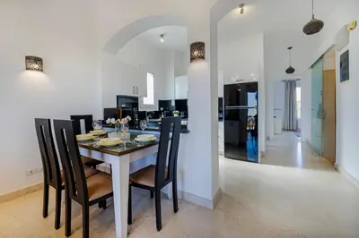 a dining room with a table and some chairs at Wonderful apartment with prime location & pool in Hurghada