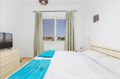 a bedroom with a white bed and a window at Wonderful apartment with prime location & pool in Hurghada