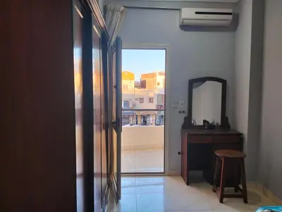 a room with a mirror and a door with a stool at Eldon apartment in Hurghada