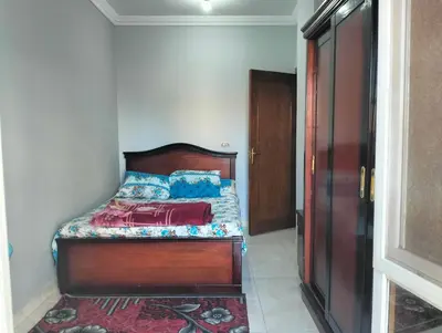 a bedroom with a bed with a wooden head board at Eldon apartment in Hurghada