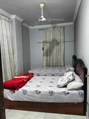 a bedroom with a bed with white sheets at Eldon apartment in Hurghada