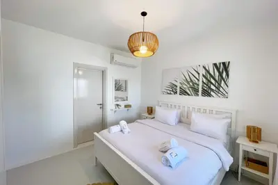a bedroom with a white bed with towels on it at Charming & Beautifully Styled 3BDR Swan Lake Gouna in Hurghada