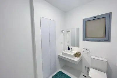 a white bathroom with a sink and a mirror at Charming & Beautifully Styled 3BDR Swan Lake Gouna in Hurghada