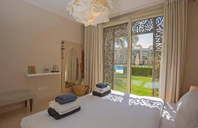 a bedroom with a bed and a large window at Ollystays Mangroovy 2 BR Beach and Pool Free access in Hurghada