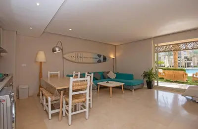 a living room with a table and a blue couch at Ollystays Mangroovy 2 BR Beach and Pool Free access in Hurghada