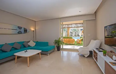 a living room with a blue couch and a table at Ollystays Mangroovy 2 BR Beach and Pool Free access in Hurghada