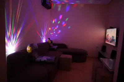 a living room with a couch and lights on the wall at Hostgool Beach Chalets Mirage bay resort & aqua park in Hurghada