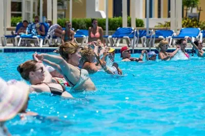 a group of people in a swimming pool at Hostgool Beach Chalets Mirage bay resort & aqua park in Hurghada