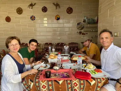a group of people sitting around a table with food at Bakar House in Aswan