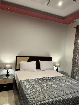 a bedroom with a bed with two tables and two lamps at Mirage Aqua Resort 2 Bedroom Apartment in Hurghada