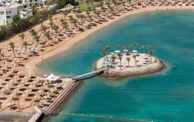 an aerial view of a beach with umbrellas and palm trees at Mirage Aqua Resort 2 Bedroom Apartment in Hurghada