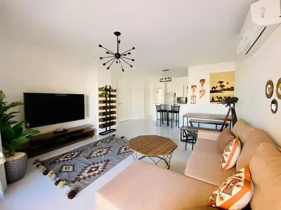 a living room with a couch and a flat screen tv at Ground Spacious 1-BR Apt @ SwanLake El Gouna ! in Hurghada