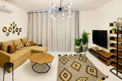 a living room with a couch and a tv at Ground Spacious 1-BR Apt @ SwanLake El Gouna ! in Hurghada