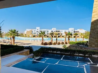 a view of a resort with a swimming pool and palm trees at Ground Spacious 1-BR Apt @ SwanLake El Gouna ! in Hurghada