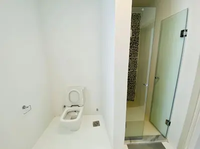 a white bathroom with a toilet and a mirror at Ground Spacious 1-BR Apt @ SwanLake El Gouna ! in Hurghada