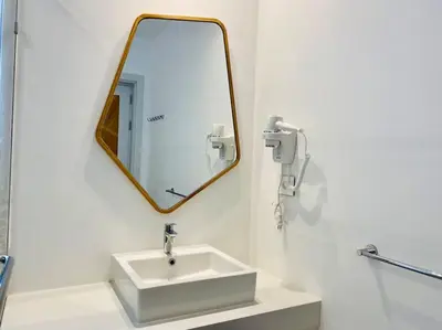 a white bathroom with a sink and a mirror at Rustic 1 BR-Apt@ Swanlake El Gouna ! in Hurghada