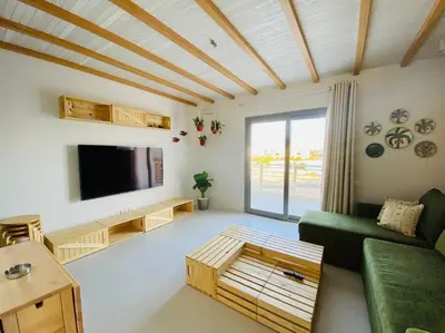 a living room with a green couch and a flat screen tv at Rustic 1 BR-Apt@ Swanlake El Gouna ! in Hurghada
