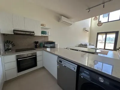 a kitchen with white cabinets and a counter top at Shedwan 3 bed and nanny room townhouse in Hurghada