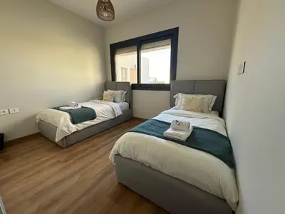 a bedroom with two beds and a window at Shedwan 3 bed and nanny room townhouse in Hurghada
