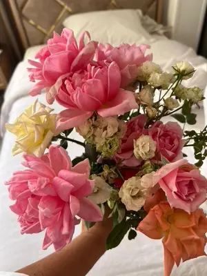a person holding a bouquet of pink flowers on a bed at Panorama Hotel in Luxor