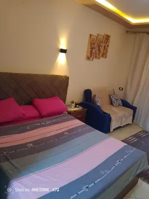 a bedroom with a bed and a couch at Florenza khamsin compound unit g4 in Hurghada