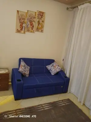a blue couch with two pillows in a living room at Florenza khamsin compound unit g4 in Hurghada