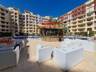a patio with white chairs and a fountain with buildings at Florenza khamsin compound unit g4 in Hurghada
