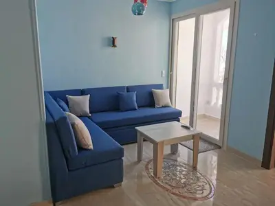 a blue couch in a living room with a table at Schöne Europäische 3 Zimmer Wohnung in Al Dahar in Hurghada