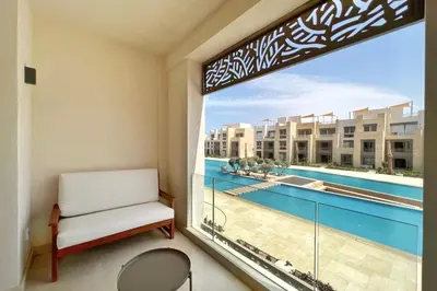 a room with a window with a view of a pool at Smooth & Snug 1 BDR Mangroovy Free Beach & Pool Access in Hurghada