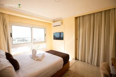 a hotel room with a bed and a window at Palm Inn Hotel Hurghada in Hurghada