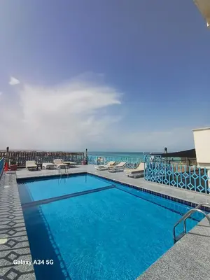 a swimming pool with the ocean in the background at Palm Inn Hotel Hurghada in Hurghada