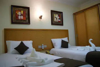 a hotel room with two beds with swans on them at Palm Inn Hotel Hurghada in Hurghada