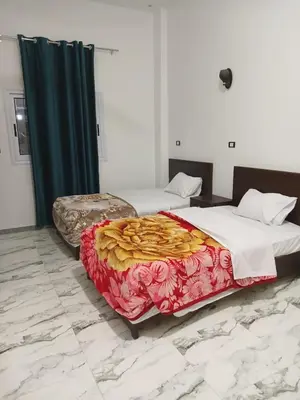 a bedroom with two beds with red and gold blankets at Sky Guest House in Luxor