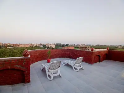 a patio with two chairs and a brick wall at Sky Guest House in Luxor